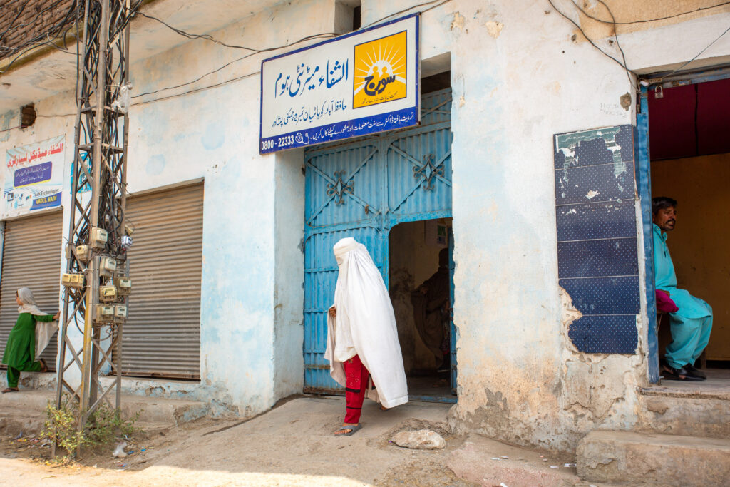 A woman wearing a white hijab leaves an MSI Soraj social franchise clinic in Pakistan.